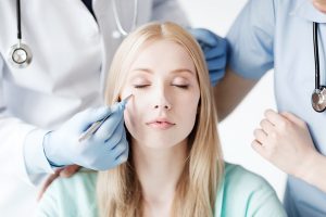 plastic surgeon and nurse with patient